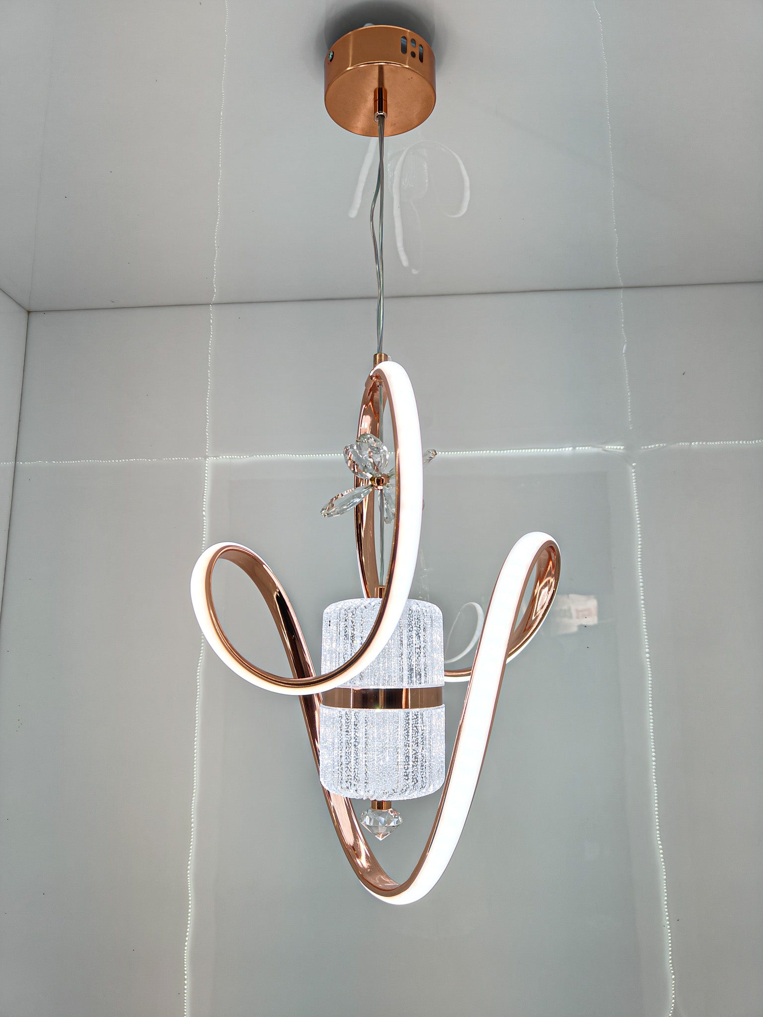Modern Swanart crystal LED pendant light with rose gold rings, adjustable height, decorative ceiling lamp for living room or dining area.