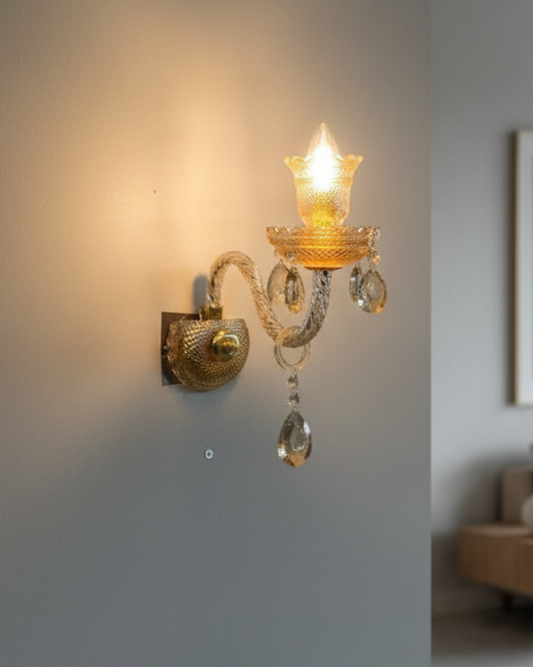 Swanart luxury crystal wall sconce with gold finish and hanging crystal drops, providing warm ambient lighting for living rooms or bedrooms.
